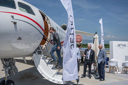 Attendees network and tour the aircraft display at the Geneva Airport on Tuesday during EBACE2019.